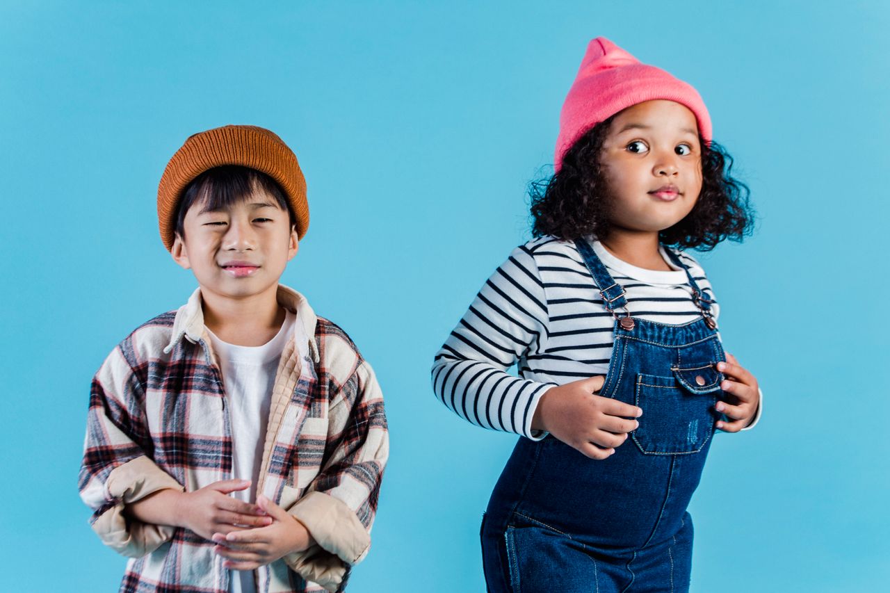 Multiethnic kids in casual clothes standing on blue background and making grimace in room
